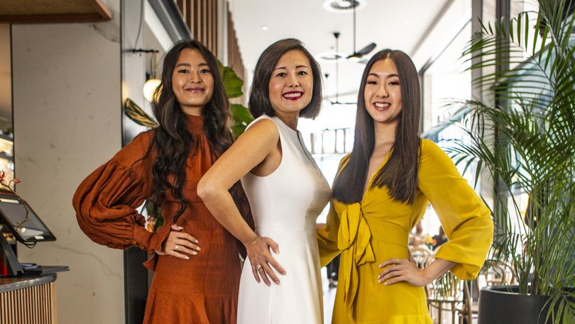 Owner and founder of Miss Chow's Group Jacquie Chan (white dress), with her two daughters Adele (orange dress) and Julia Chan (yellow dress), at the company's South Perth restaurant.